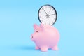 Clock being put into a pink piggy bank on blue background Royalty Free Stock Photo