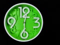 Clock on black background. The time is 12:30 am or pm. Twelve o'clock pass thirty minutes am or pm.