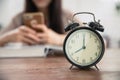 Clock with blur girl teen playing smartphone while reading book