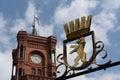 Clock on a building with a lion steel sign