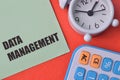 Clock, calculator and green note with text DATA MANAGEMENT Royalty Free Stock Photo