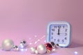 Clock and Christmas silver balls with red candles. Blurred lights in the background. New Year Royalty Free Stock Photo