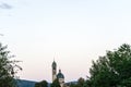 Clock church tower seen through tree at sunset blue hour Royalty Free Stock Photo