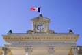 Clock on city hall in France town with french flag in wind Royalty Free Stock Photo