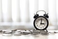 Clock and coins on desk table area window, Time is money