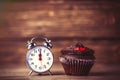 Clock and cupcake on the table Royalty Free Stock Photo