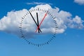 Clock dial shows the time 5 before 12 with sky and cloud background. Royalty Free Stock Photo