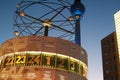 Clock for different time zones on Alexanderplatz square in Berlin, Germany at twilight.