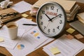 A Clock Displaying Deadline Surrounded by Papers, Coffee, and Office Supplies Royalty Free Stock Photo