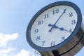 Clock Displaying Four Oclock Against a Clear Blue Sky With Scattered Clouds in a Park Setting During the Afternoon Royalty Free Stock Photo