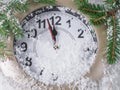 Clock on snow under decorated christmas tree Royalty Free Stock Photo