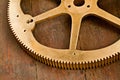 Clock gear, gold and wheel cog on a wood table with golden machinery and gears. Metal, closeup and steel with machine Royalty Free Stock Photo