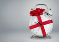 Clock in gift ribbon on grey, time to gift cocept, copy space. Royalty Free Stock Photo