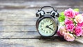 Clock gold retro and flowers on a wooden table.