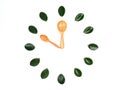 The clock with green leaves and eco-friendly wooden spoons design on white background Royalty Free Stock Photo