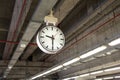 Clock is hanging on the steel arch roof structure at train station Royalty Free Stock Photo