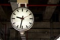 Clock is hanging on the steel arch roof structure at train station Royalty Free Stock Photo