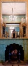 A fireplace with ornate clock on it reflected in a mirror in the Royal Pavilion.