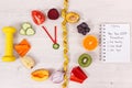 Clock made of fruits and vegetables, dumbbell and centimeter, new year resolutions of healthy lifestyles Royalty Free Stock Photo