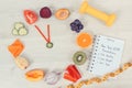 Clock made of fruits and vegetables, dumbbell and centimeter, new year resolutions of healthy lifestyles Royalty Free Stock Photo