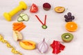 Clock made of fruits and vegetables showing time of 23 hours 55 minutes, dumbbell and centimeter, new year resolutions concept Royalty Free Stock Photo