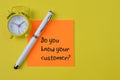 Clock, pen and memo note with question DO YOU KNOW YOUR CUSTOMER