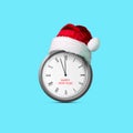 Clock in a Santa Claus hat. Isolated on blue background. Design element. Christmas background. Festive Royalty Free Stock Photo