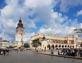 A clock tower and a bazaar. The central square of the city of Krakow. Medieval architecture of Poland.