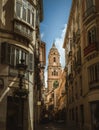 Clock Tower of the Cathedral of Malaga, view from a narrow street between houses Royalty Free Stock Photo