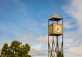 Clock tower in the central of a city. Wooden street tower clock on the blue sky background