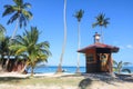 The clock tower on the coconut beach. Lifeguard tower , Hut or Cottage against the blue sky Royalty Free Stock Photo