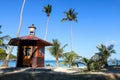 The clock tower on the coconut beach. Lifeguard tower , Hut or Cottage against the blue sky Royalty Free Stock Photo