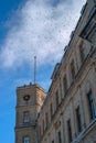 Clock Tower of the Gatchina Palace. Winter, sunny. Above the tower birds are circling. Russia. Royalty Free Stock Photo