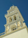 A Clock Tower On The Side Of A White Building Under A Blue Sky