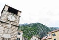 Clock tower in the Square of the Arms, with the mountains in the background. Kotor, Montenegro. Stone architecture building in old Royalty Free Stock Photo