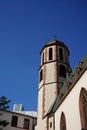 the clock tower is on top of a building, next to trees and blue sky Royalty Free Stock Photo