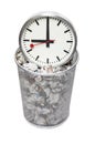 Clock in wastebasket full of crumpled paper over white background