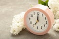 Clock with white flowers on grey background