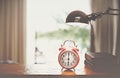 Clock on wood in the morning, blurred bedroom background Royalty Free Stock Photo