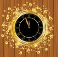 Clock on a wooden background with gold spangles