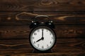 Clock on a wooden background. The clock shows the time of eight o`clock in the afternoon. Royalty Free Stock Photo