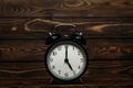 Clock on a wooden background. The clock shows the time of five o`clock in the afternoon. Clock showing the time of five o`clock Royalty Free Stock Photo