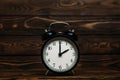 Clock on a wooden background. The clock shows the time of two o`clock in the afternoon. Clock showing the time of two o`clock in Royalty Free Stock Photo