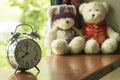 Clock on wooden table with blurred teddy bear Royalty Free Stock Photo