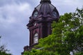 Clocktower of Newnan, Georgia courthouse behind trees with blue sky