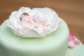 Cloes up of green baptism cake with green fondant and a baby on