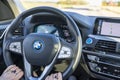 Cloes up view of female hands on steering wheel of BMWiX3.