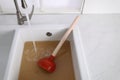 Clogged kitchen sink with plunger and dirty water Royalty Free Stock Photo