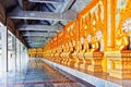 A cloister of Phra Maha Chedi Chai Mongkol lined by row of Buddhist monk statues in Roi Et province, northeastern Thailand