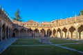 Cloister of the University of Salamanca with grass and a stone well beautifully illuminated by the light of the evening sun,